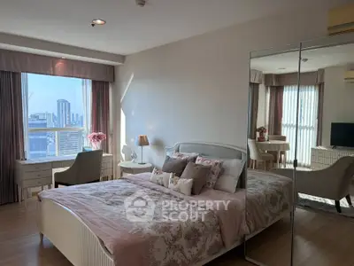 Luxurious bedroom with city view, elegant decor, and ample natural light.