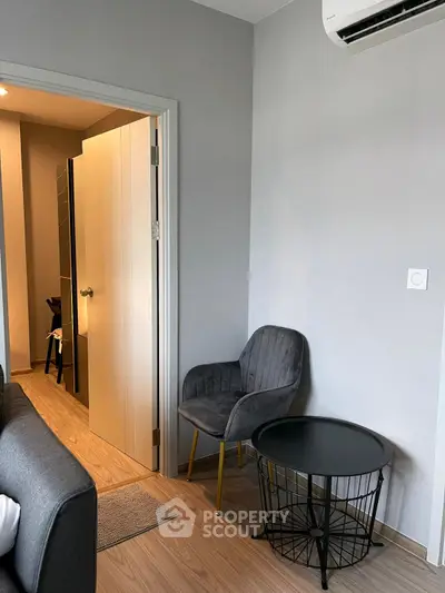 Modern living room with stylish chair and table, featuring sleek air conditioning unit.