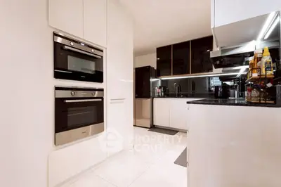 Modern kitchen with sleek appliances and glossy cabinets in a contemporary home.