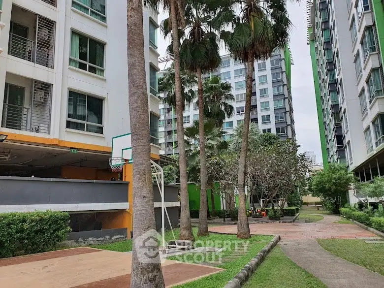 Modern residential complex with lush greenery and basketball court