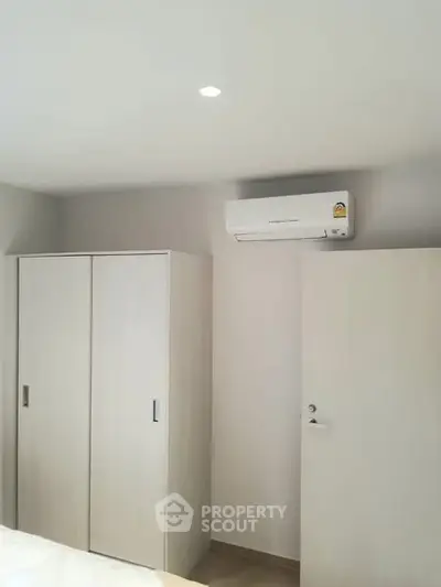 Modern bedroom with air conditioning and minimalist wardrobe design.