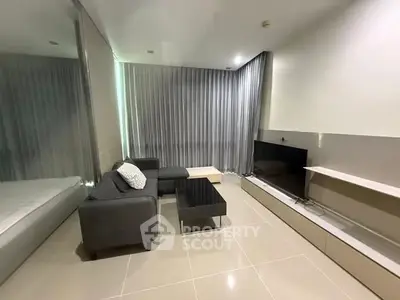 Modern living room with sleek furniture and large TV, perfect for relaxation and entertainment.