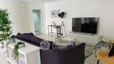 Spacious living room with modern decor and large TV, perfect for relaxation and entertainment.