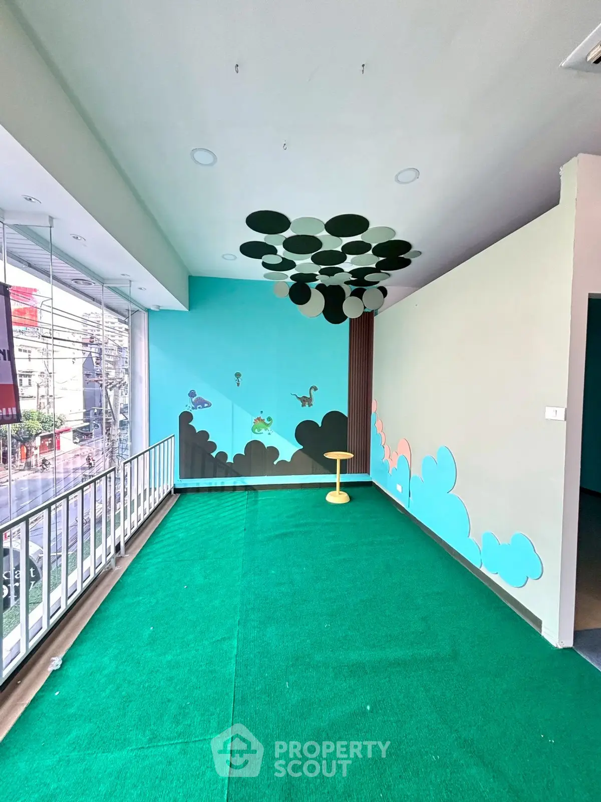 Vibrant interior space with colorful wall art and green flooring, perfect for creative use.