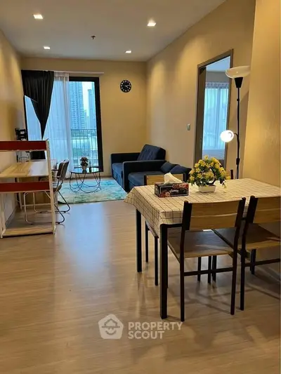 Modern living room with dining area, cozy sofa, and city view from window.