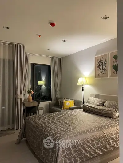 Elegant bedroom with modern decor and city view, featuring cozy lighting and stylish furnishings.
