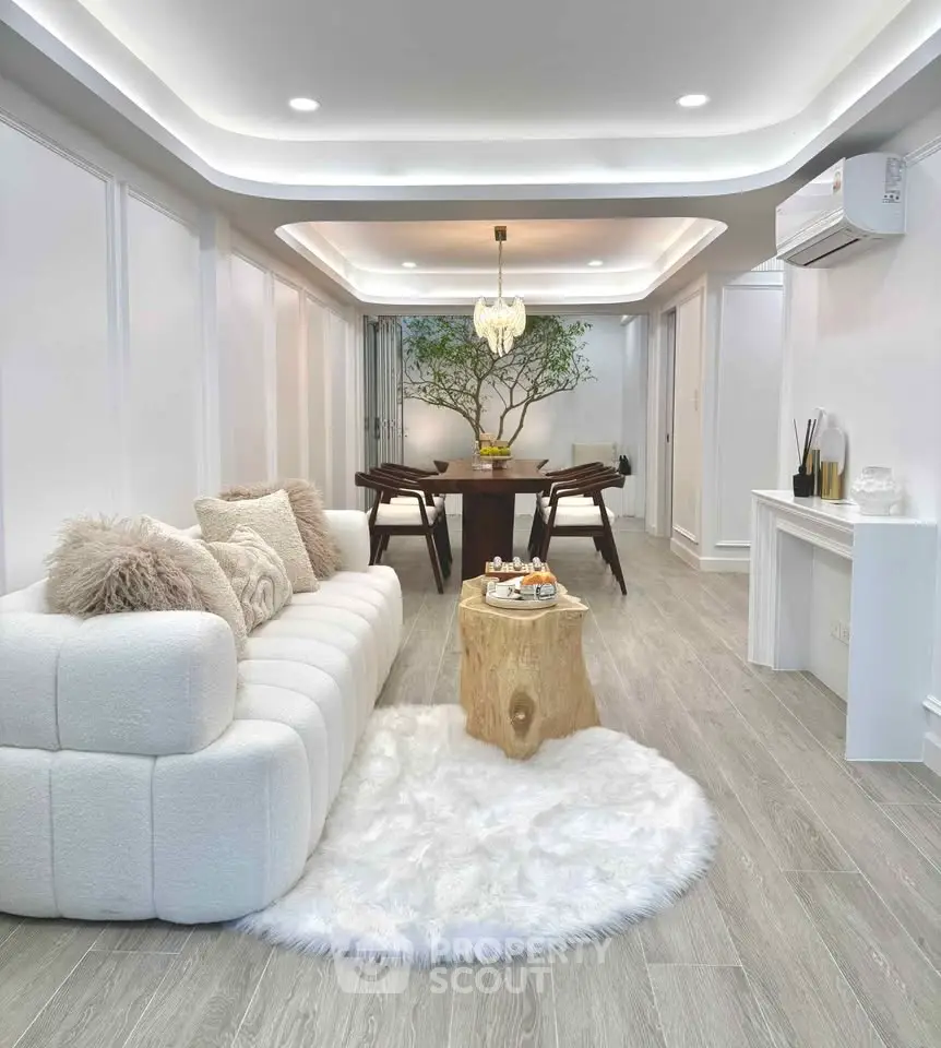 Luxurious modern living room with elegant decor and cozy ambiance, featuring plush sofa and stylish dining area.
