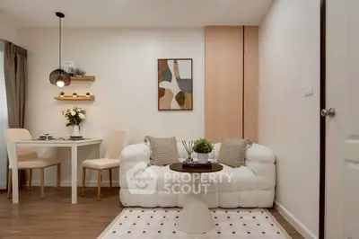 Chic modern living room with cozy white sofa, stylish decor, and elegant dining area.