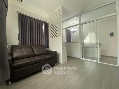 Modern living room with sleek sofa and partition, featuring elegant curtains and stylish flooring.
