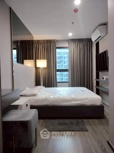 Modern bedroom with sleek design, featuring a comfortable bed, large window, and stylish decor.