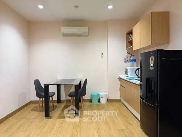 Modern kitchen with sleek black fridge and minimalist dining area