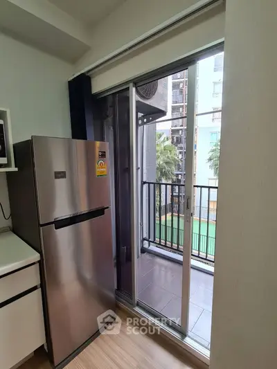 Modern kitchen with sleek fridge and balcony view in urban apartment