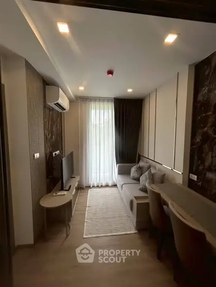 Modern living room with stylish decor and natural light, featuring a cozy sofa and dining area.