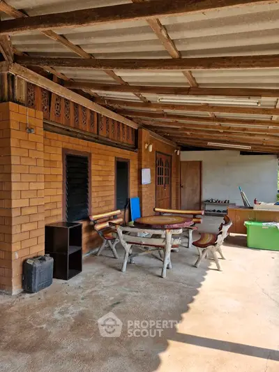 Charming rustic patio with wooden furniture and brick walls, perfect for outdoor relaxation.