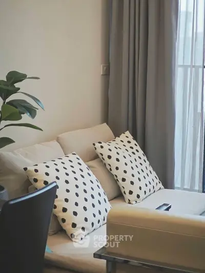 Cozy living room with stylish polka dot cushions and elegant curtains