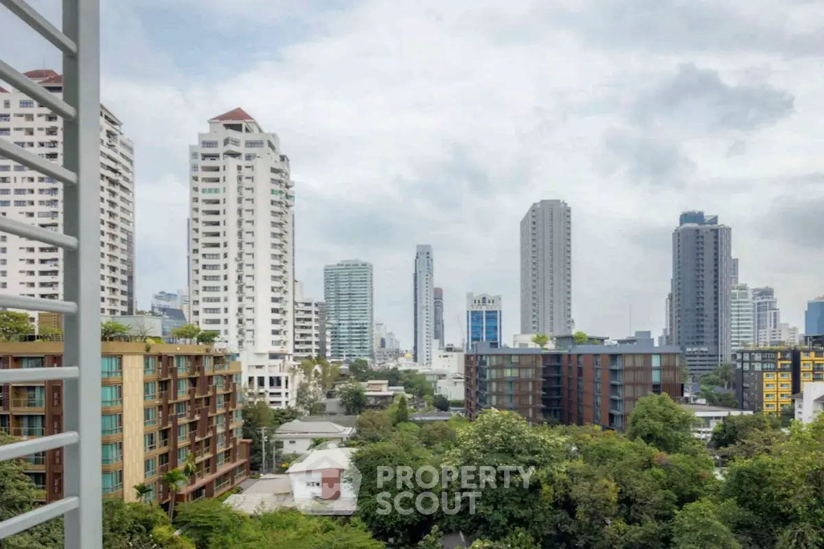 Stunning cityscape view from a high-rise balcony overlooking modern skyscrapers and lush greenery.