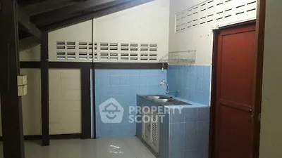 Compact kitchen space with blue tile backsplash, wooden beams, and a convenient sink area, ideal for efficient urban living.