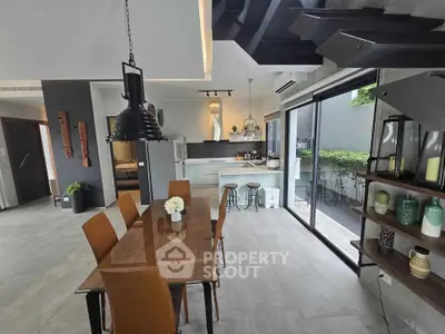 Modern open-plan kitchen and dining area with stylish decor and large windows.