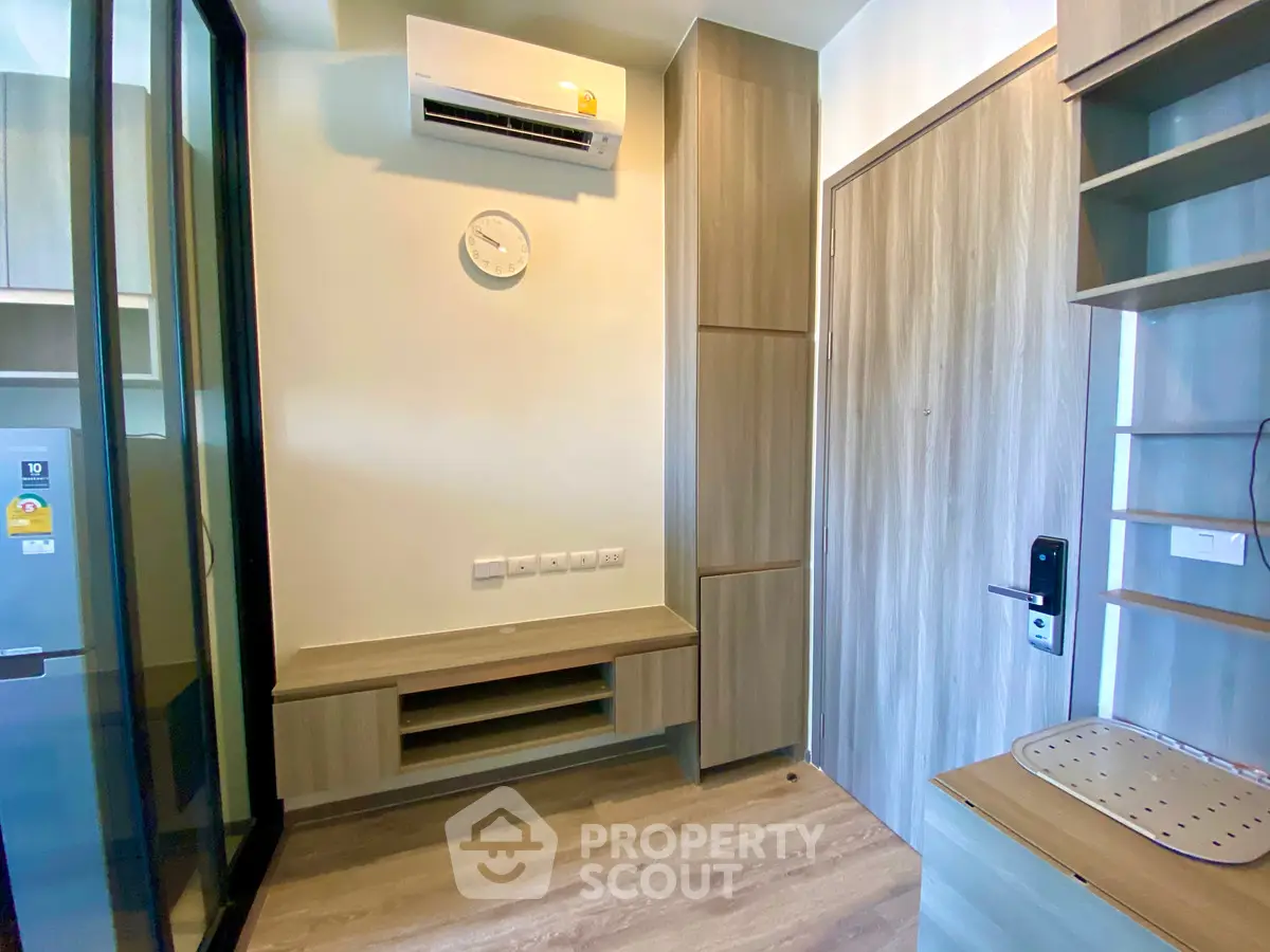 Modern apartment interior with sleek wooden storage and air conditioning unit, ideal for compact living.