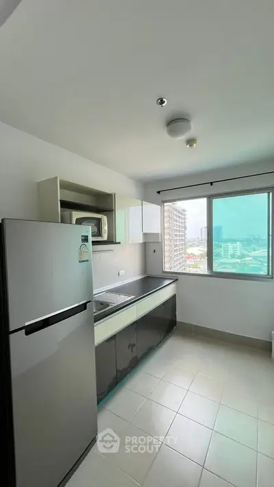 Modern kitchen with city view, featuring sleek appliances and ample natural light.