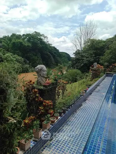 Stunning poolside view with lush greenery and serene river backdrop