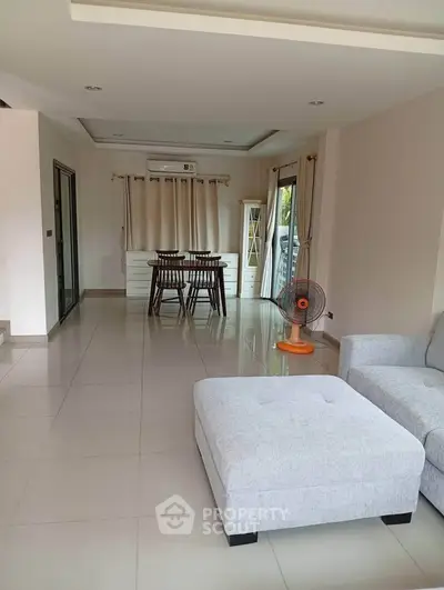 Spacious living room with modern dining area and cozy seating, perfect for family gatherings.