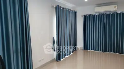 Spacious room with elegant blue curtains and modern air conditioning unit.