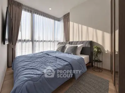 Modern bedroom with large windows and stylish decor in a luxury apartment.