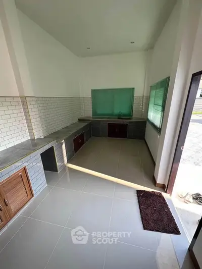 Spacious kitchen with modern tiled countertops and ample natural light.