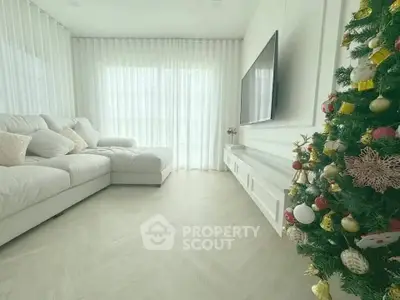 Elegant living room with cozy sofa and festive Christmas tree