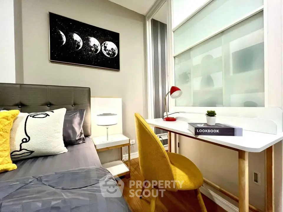 Stylish bedroom with modern decor and cozy study area, featuring a sleek desk and vibrant yellow chair.