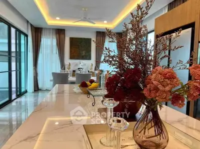 Luxurious open-plan living room with elegant decor and large windows for natural light.
