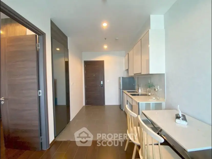 Modern apartment interior with sleek kitchen and dining area, featuring contemporary design and ample natural light.