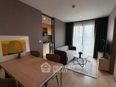 Modern living room with stylish decor and open kitchen in a high-rise apartment.