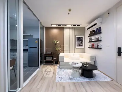 Modern living room with open kitchen, stylish decor, and cozy ambiance in a contemporary apartment.