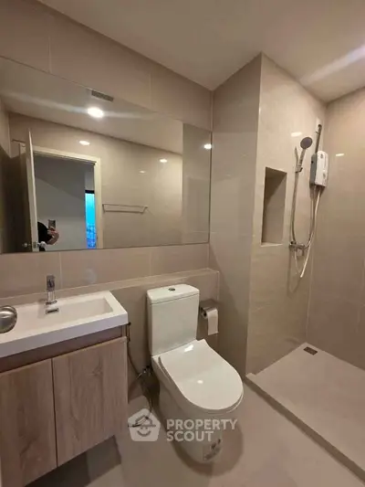 Modern bathroom with sleek fixtures and spacious shower in contemporary apartment.