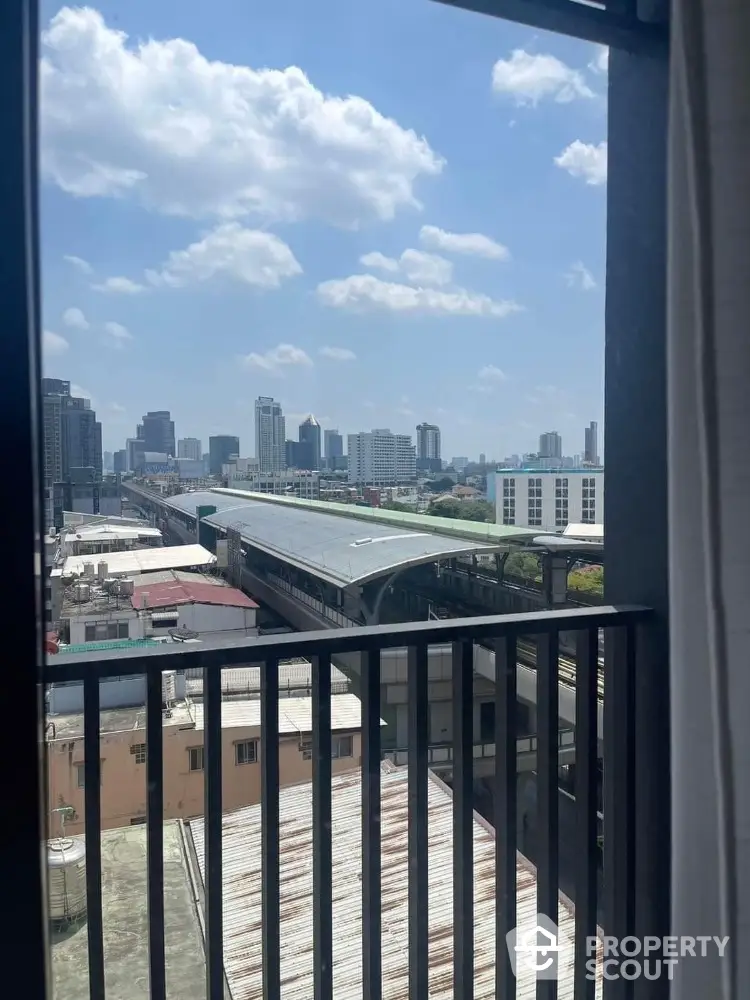 Stunning urban view from high-rise balcony overlooking city skyline and train station.