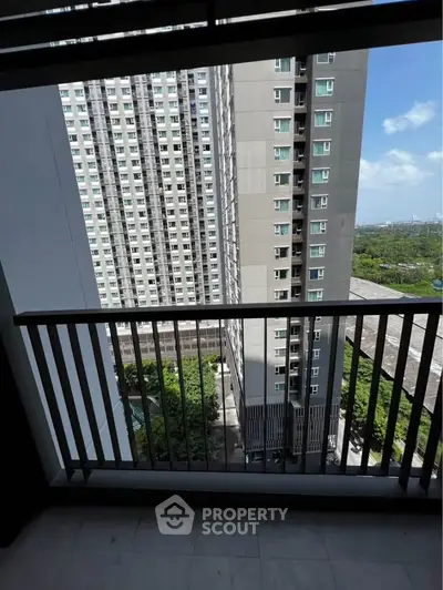 High-rise apartment balcony with cityscape view and modern railing design.