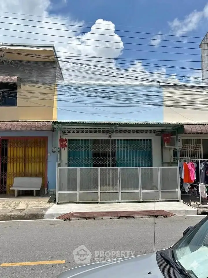 Charming townhouse with gated entrance and vibrant facade in a sunny neighborhood.