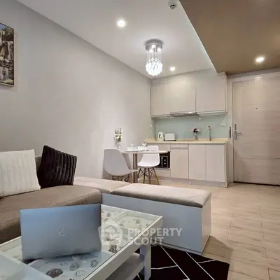 Modern living room with open kitchen, stylish decor, and cozy seating area in a contemporary apartment.