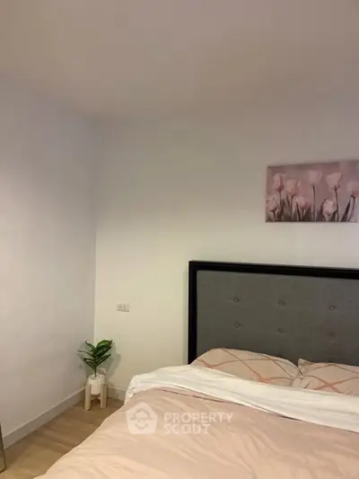 Cozy bedroom with elegant decor and soft lighting, featuring a stylish bed and wall art.