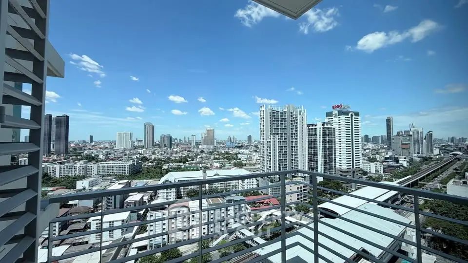 Stunning cityscape view from a high-rise balcony with clear blue skies.