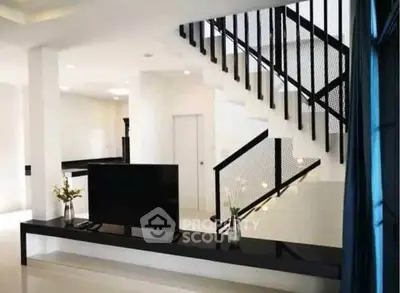 Modern living room with sleek staircase and minimalist decor