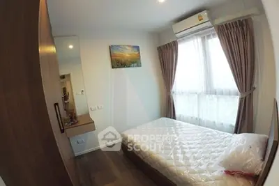 Cozy bedroom with natural light and modern furnishings in a stylish apartment.