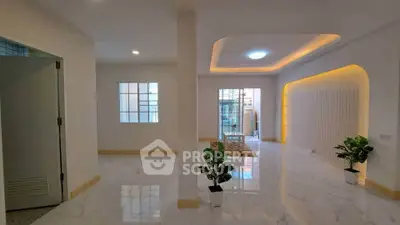 Spacious modern living room with elegant lighting and marble flooring, perfect for stylish urban living.