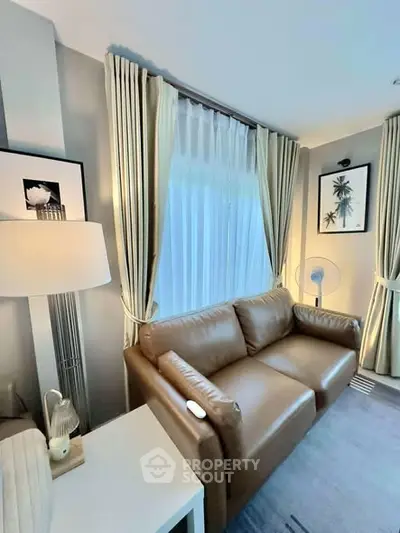 Cozy living room with leather sofa and elegant curtains, perfect for relaxation.