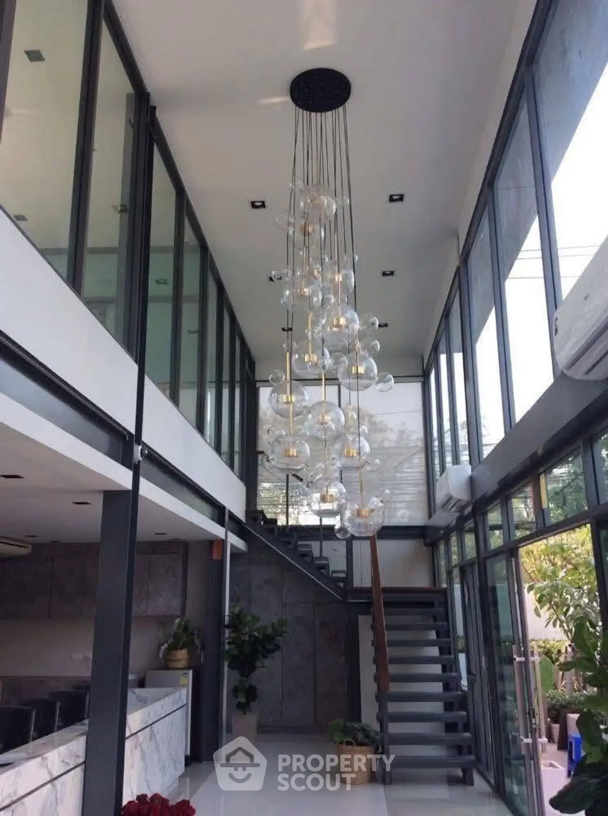Stunning modern interior with high ceilings and elegant chandelier in a spacious living area.
