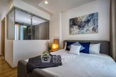 Modern bedroom with stylish decor and ensuite bathroom, featuring cozy bed and elegant lighting.