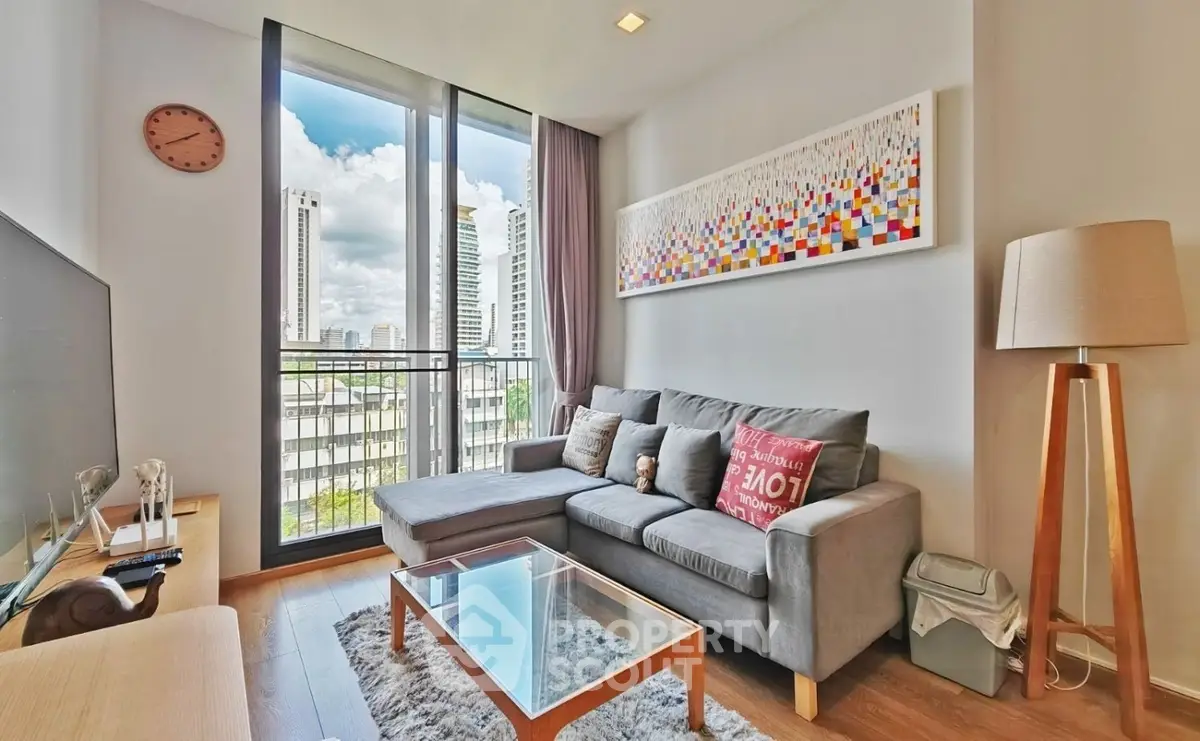 Modern living room with large window and city view, featuring stylish decor and comfortable seating.