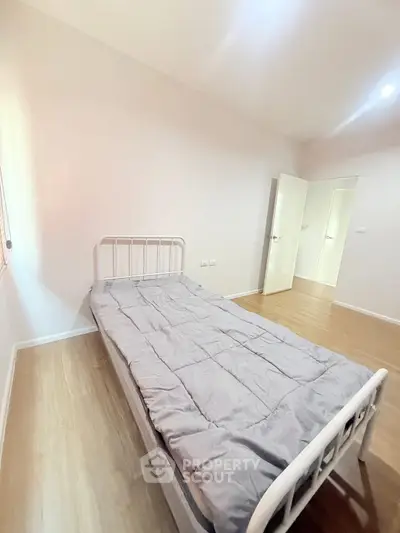 Minimalist bedroom with single bed and wooden flooring